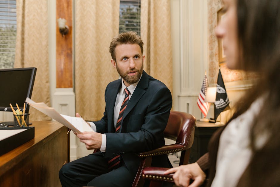 Businessman in suit discussing legal documents in office environment.