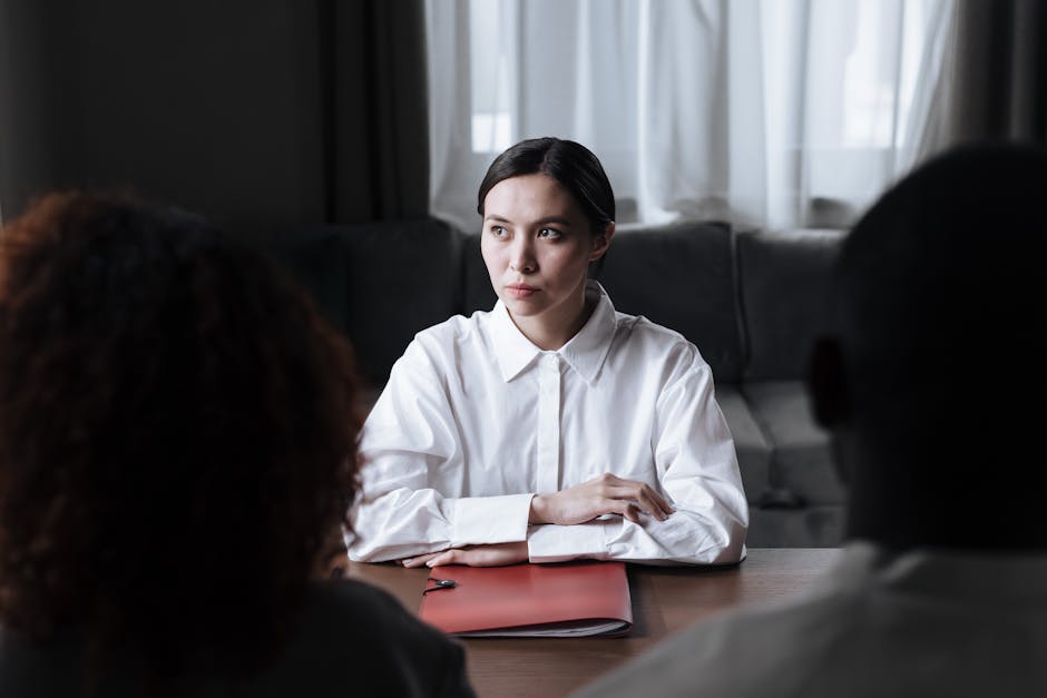Business meeting with woman in a white shirt discussing documents with clients.