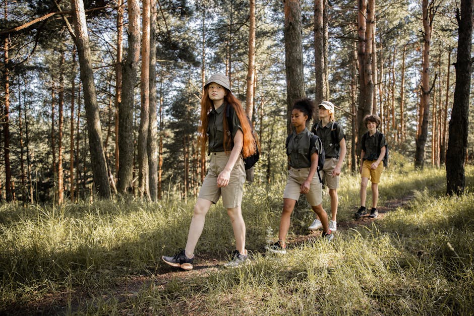 Group of teenagers hiking through a forest trail, enjoying nature and exploration.